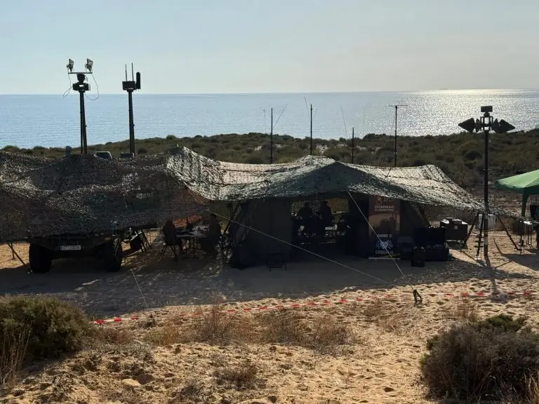 Puesto de mando camuflado junto a la costa durante el ejercicio ATLAS, con mástiles de sensores y antenas.