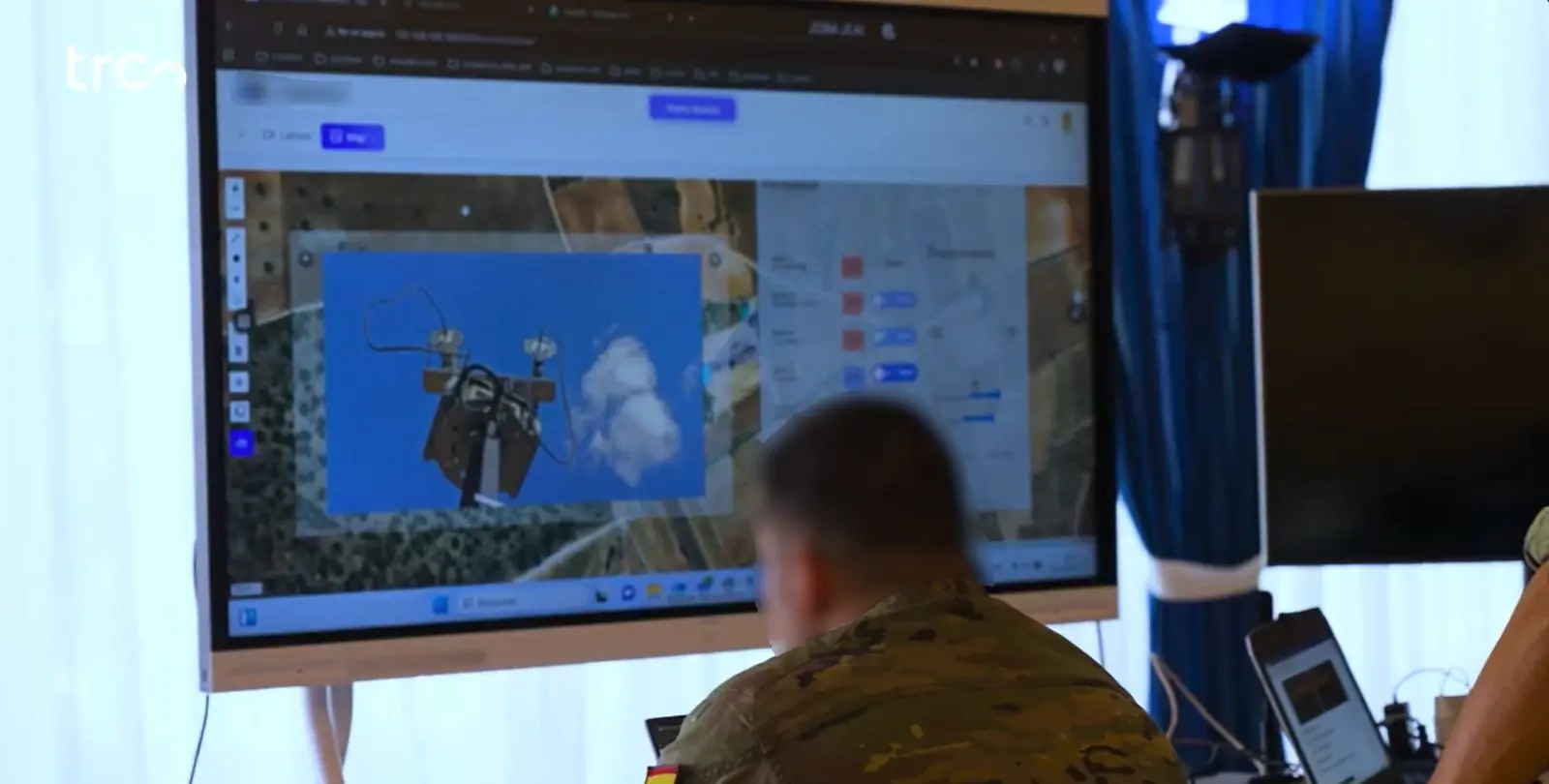 Operador del Ejército de Tierra ante una pantalla con la interfaz de NEXOR: un mapa por satélite y el vídeo de un dron.